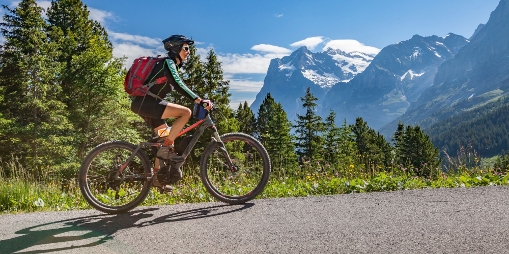 A woman biking along a mountain trail.