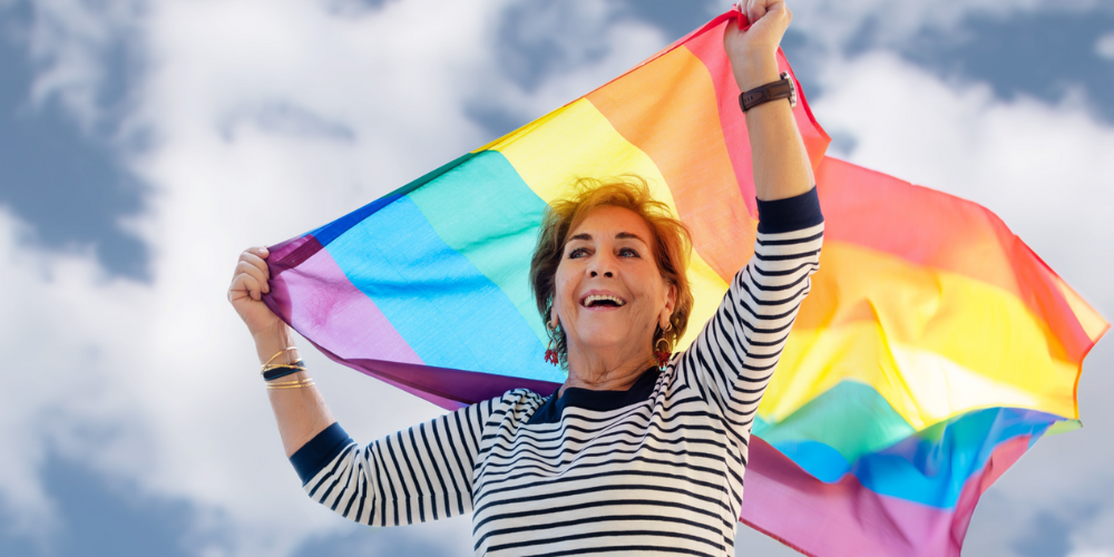 Femme adulte tenant un drapeau arc-en-ciel
