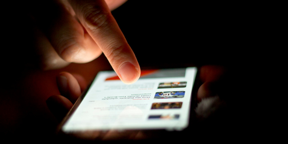 Closeup of male hands using smartphone.