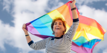 Femme adulte tenant un drapeau arc-en-ciel